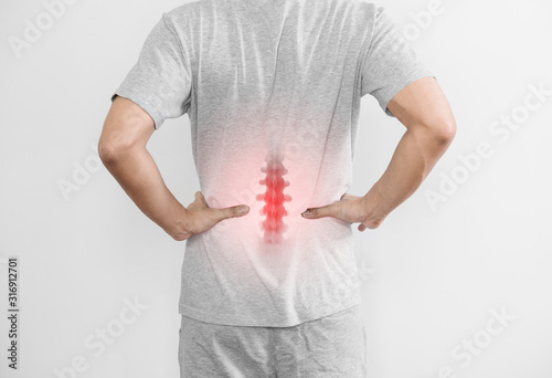 Office syndrome, Backache and Lower Back Pain Concept. a man touching his lower back at pain point