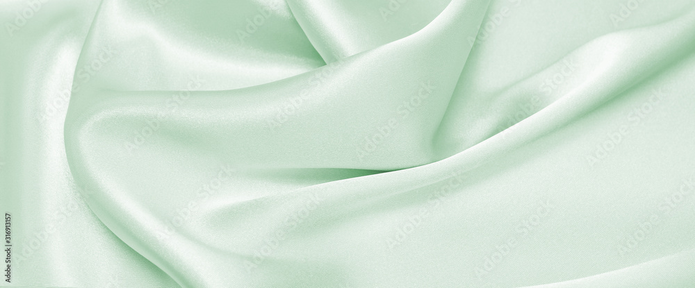 Obraz premium Draped satin green fabric for festive backgrounds