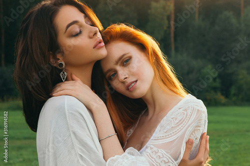 Beautiful gay couple sharing time together and having fun outdoor. Women friendship. Girls in boho fashion clothes. Happy girlfriends having tender moments. LGBT and relationship concept