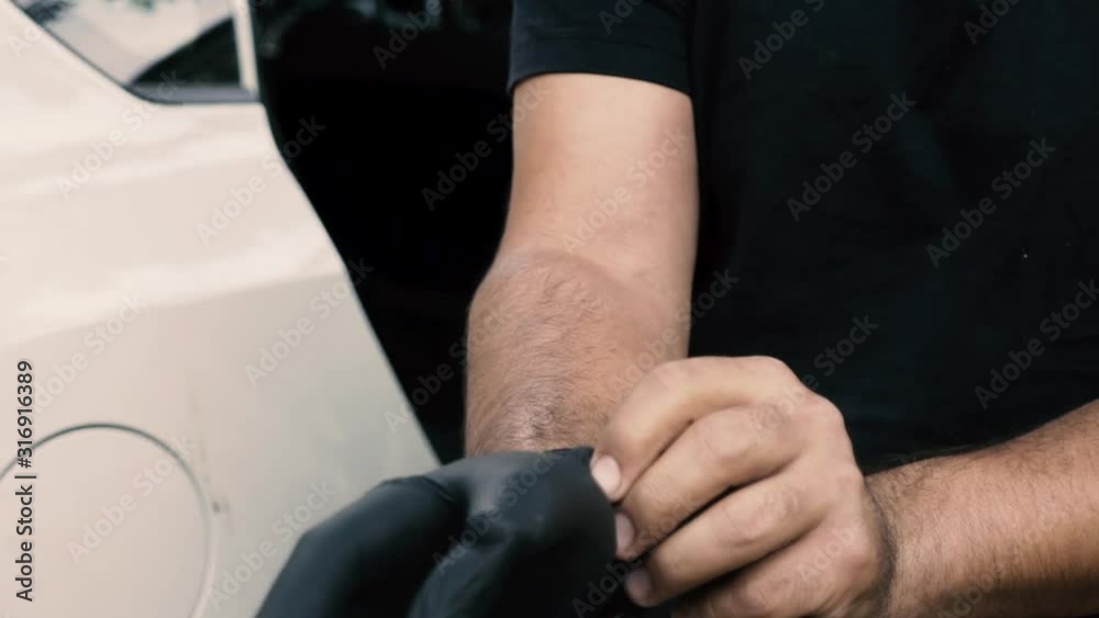Close up of a male wearing a black to wash a car Close up of a male wearing a black to wash a car