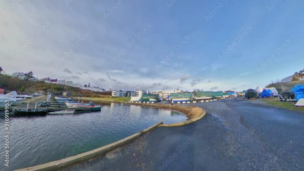 Cycling out along the boat moorings in Grombukta in Grimstad, Norway in mid-winter. Taken on a wide-angle camera and reframed. Cycling out along the boat moorings in Grombukta in Grimstad, Norway in mid-winter. Taken on a wide-angle camera and reframed.