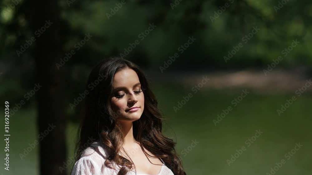 Girl in white dress stands in the sun Girl in white dress stands in the sun