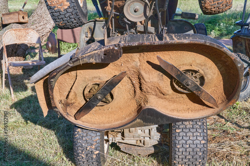 Underside view of old worn out double Lawn Mower Blades on riding lawn mower deck