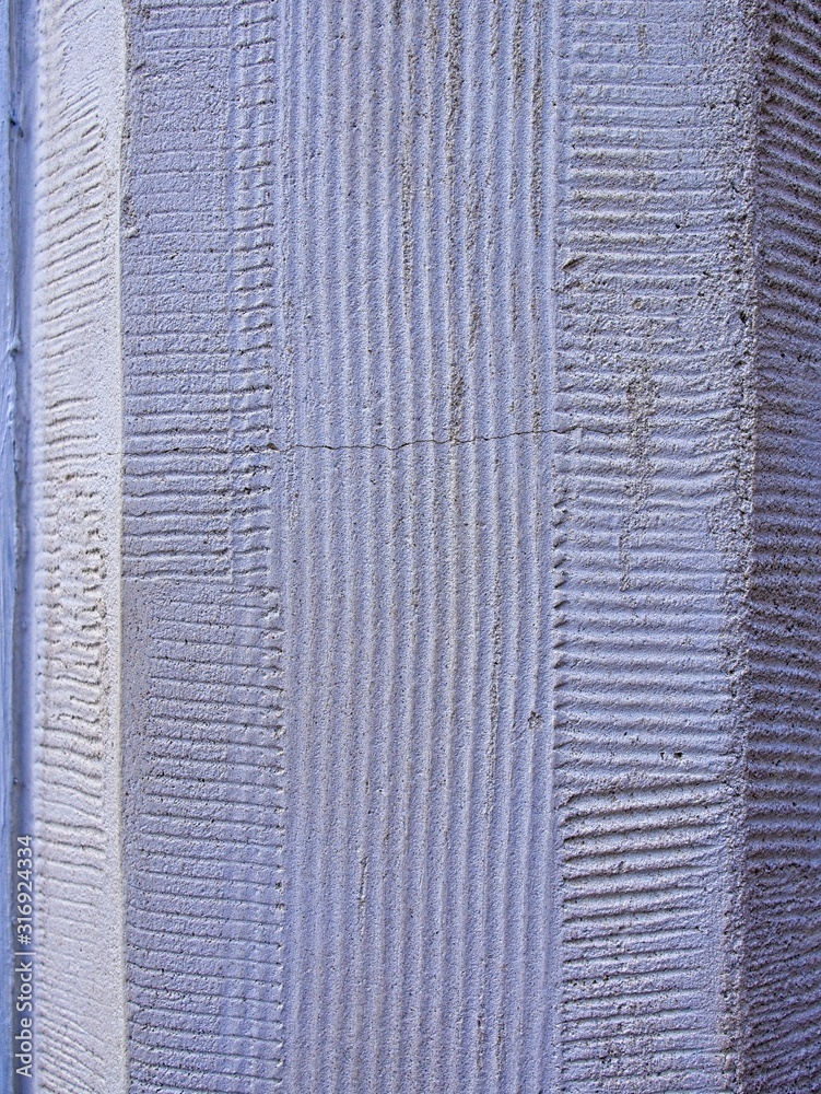 Fototapeta premium Vertical: Historic building stones with textured, artistically designed patterns.