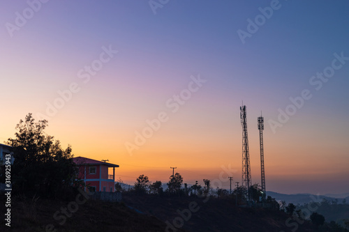 Telecommunication tower on top of the mountain with colorful sky at sunrise or sunset time.