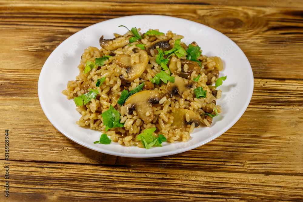 Tasty risotto with mushrooms on wooden table Tasty risotto with mushrooms on wooden table