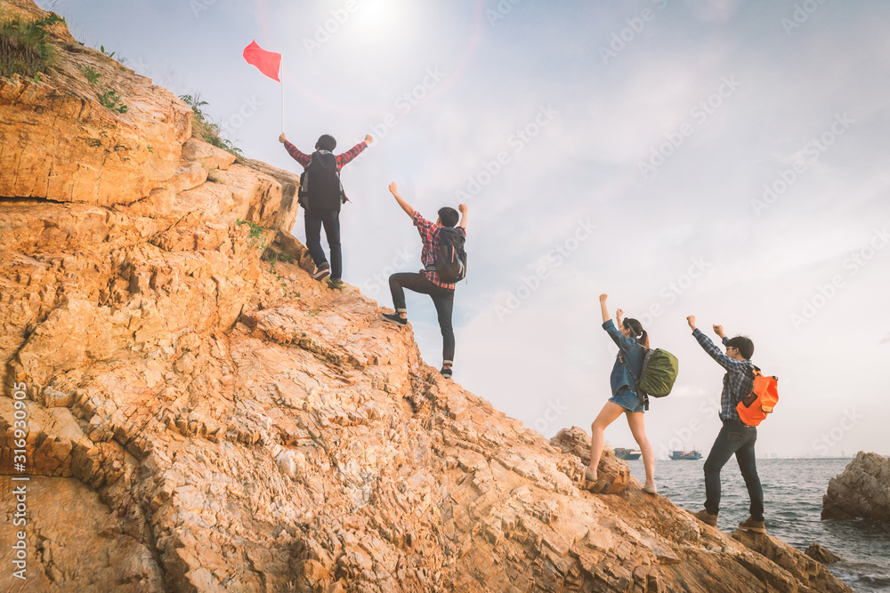 Happy group of hiker they are raised both arms and having fun when reaching the destination. View from behind. Happy group of hiker they are raised both arms and having fun when reaching the destination. View from behind.
