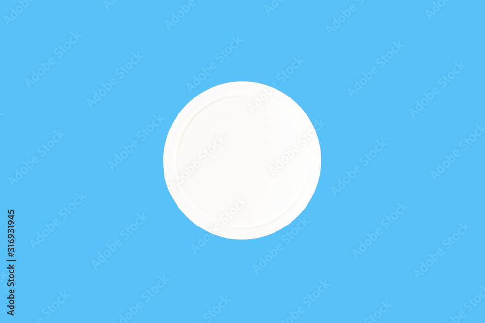 white plastic cap for jar isolated on blue, top view