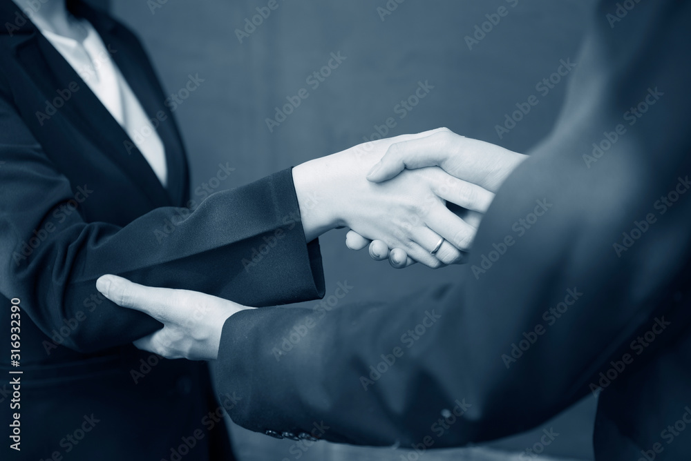 Business man and woman is check hand together as for cooperation business concept.