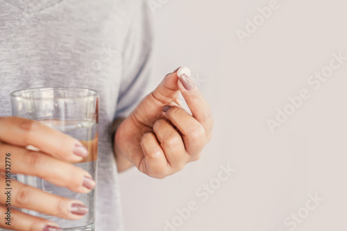 Fotografia closeup woman hand taking pill with glass of water, healthcare and medical conce