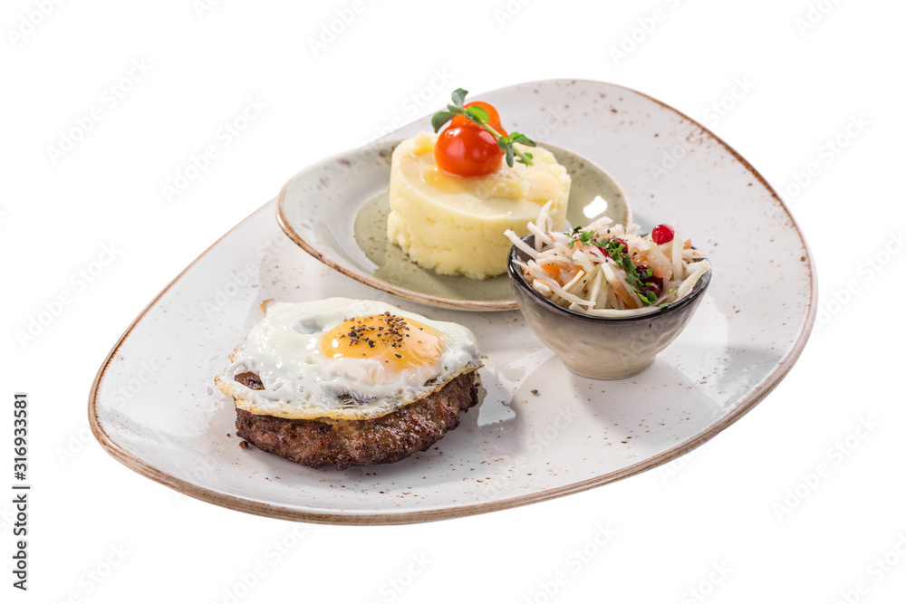 Fried egg with beefsteak, mashed potatoes and pickled cabbage on white plate isolated on white background