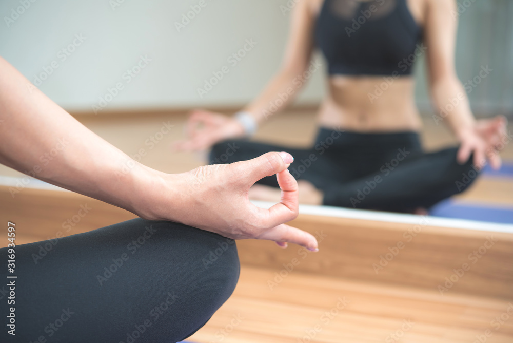 Beautiful Asian woman doing yoga meditation exercise in the room at sport club.	