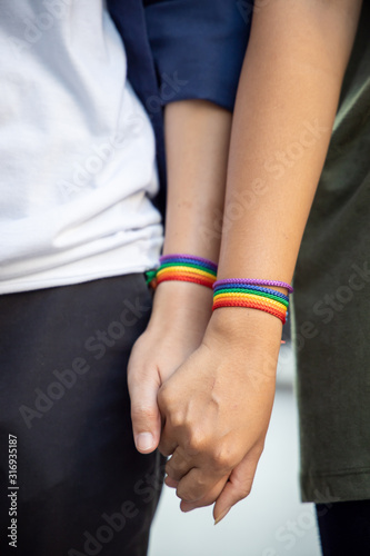 hand of LGBT women holding together with rainbow ribbon symbol  concept of LGBT pride, LGBTQ people, lgbt rights campaign, same sex marriage © 9nong