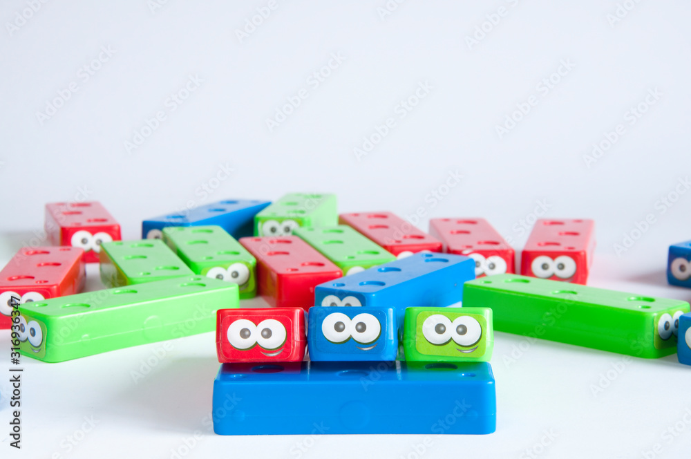 Obraz premium Children's plastic designer multicolored folded on top of each other. Artificial eyes. On white background