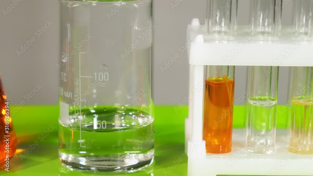 Test tubes, flasks and also other devices stand on the table in the laboratory. Test tubes, flasks and also other devices stand on the table in the laboratory.