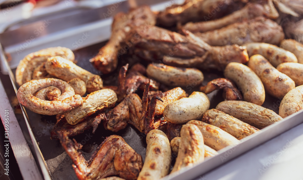 Grilled sausages and chicken legs on charcoal grill Grilled sausages and chicken legs on charcoal grill