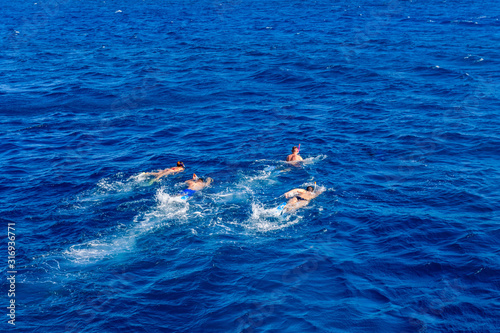 Group of tourists snorkeling in a Red sea. Summer vacation concept