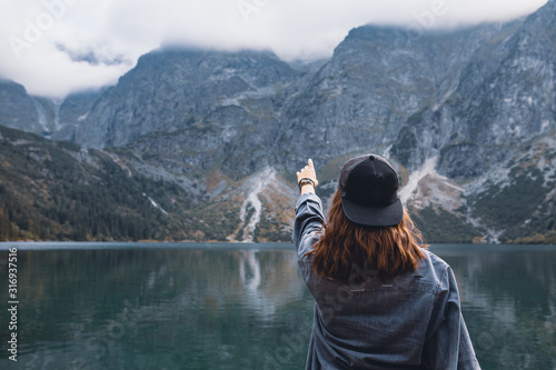 woman trying reach out the sky landscape view of lake at mountains
