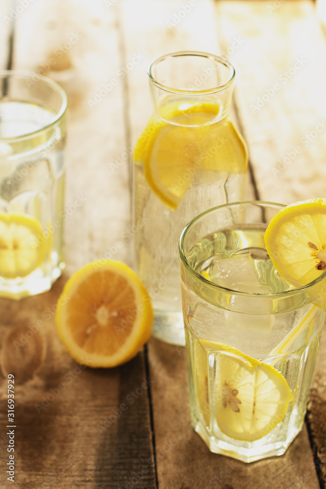 Preparation of the lemonade drink. Lemonade in the jug and lemons with mint on the table outdoor Preparation of the lemonade drink. Lemonade in the jug and lemons with mint on the table outdoor