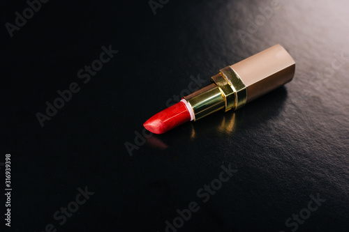 Red lipstick on a black background. Used cosmetics. Ladies Cosmetic Bag Contents