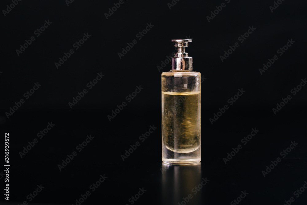 Glass bottle with perfume on a black background. Glass bottle with perfume on a black background.
