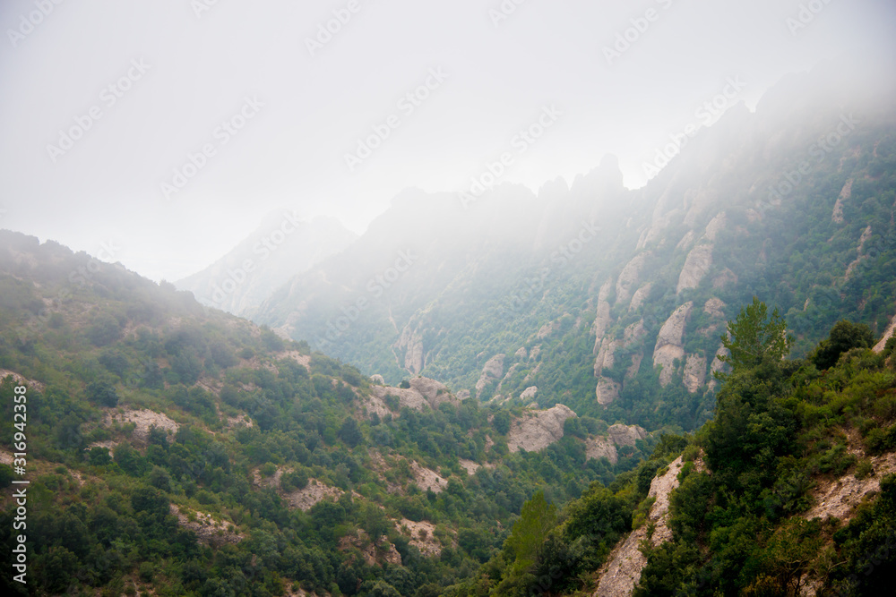 Fototapeta premium BARCELONA, SPAIN - December 26, 2018: The mountains of Montserrat in Barcelona, Spain. Montserrat is a Spanish shaped mountain which influenced Antoni Gaudi to make his art works.