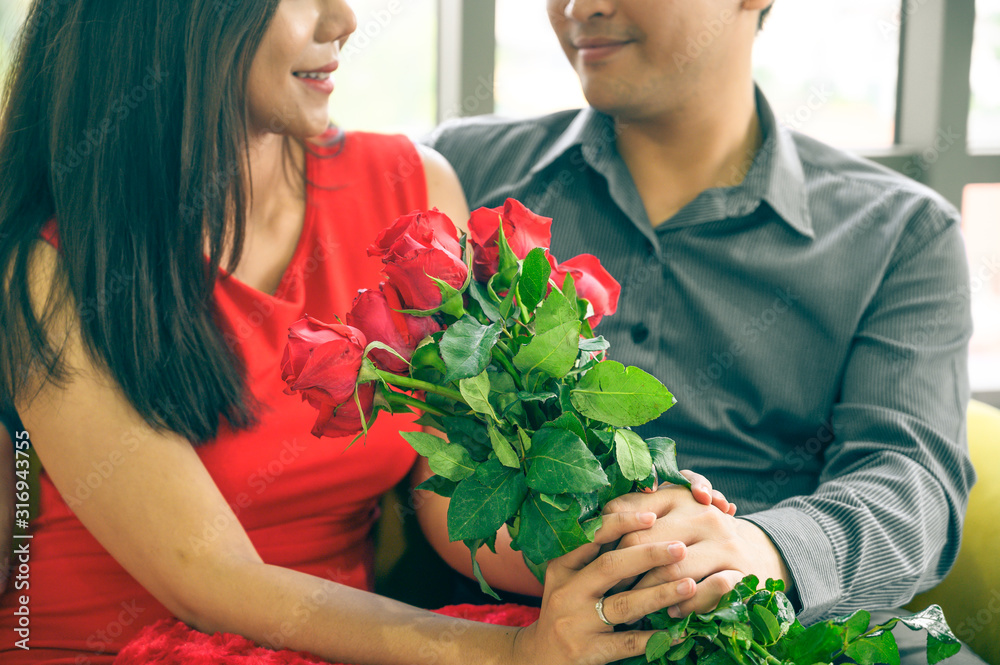 Man giving flowers to his lover on Valentine Day at home.