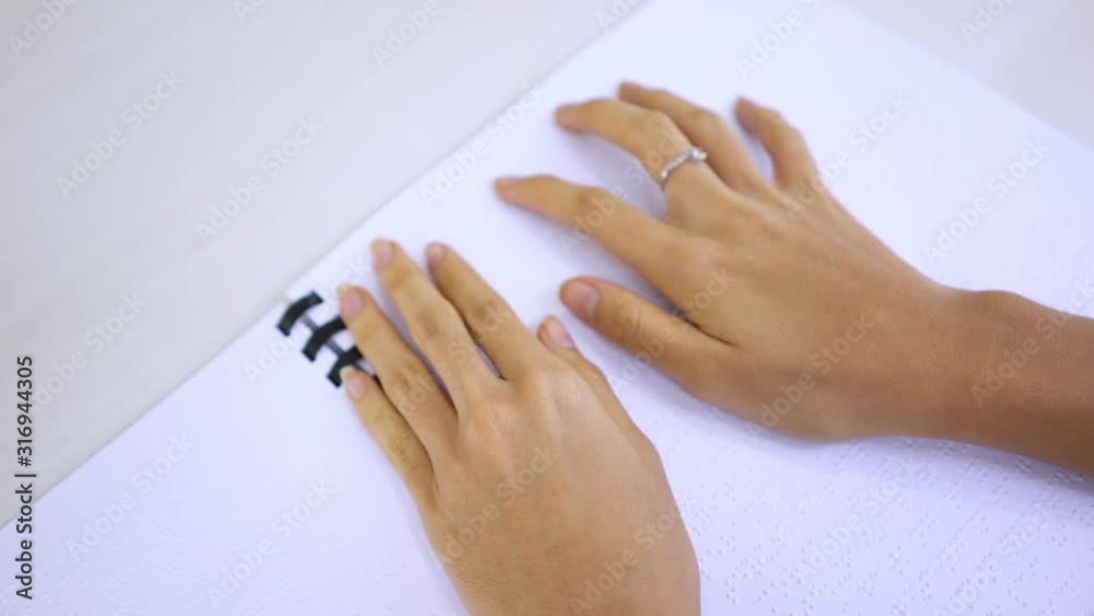 Unknown blind woman hands reading a braille book Unknown blind woman hands reading a braille book