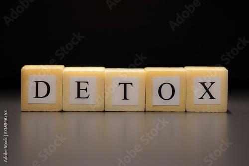 Obraz na plátně The word DETOX written on wooden cubes isolated on black background