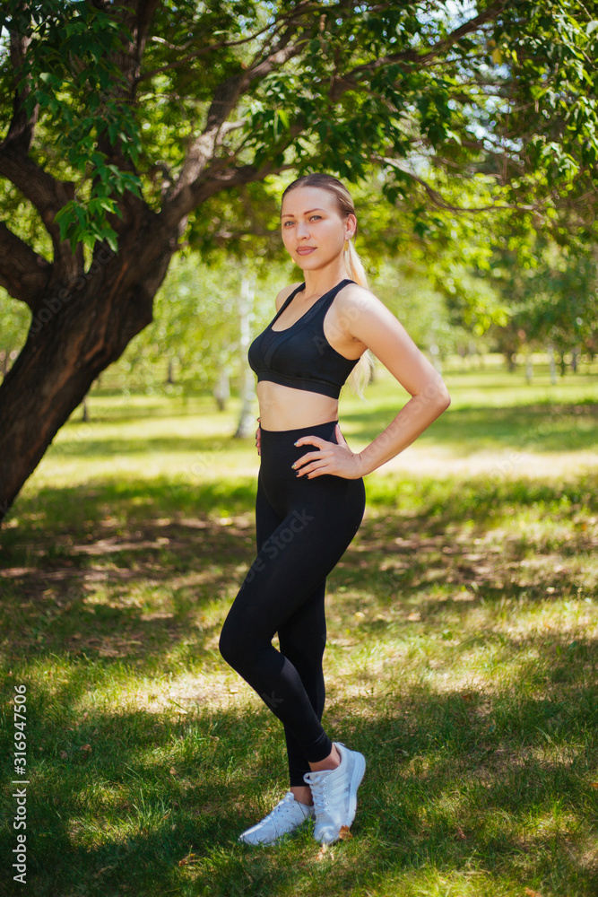 Beautiful girl in sportswear, black clothes playing sports outdoors in the park. Beautiful girl in sportswear, black clothes playing sports outdoors in the park.