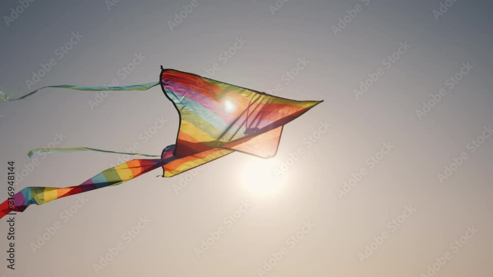 The sun illuminates the kite that soars in the sky