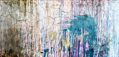 Colorful abstract cracked wall background with stained paint with vignette. Fragment of an abstract wall close up. Colored cracked wall. Dirty colored spots grunge background. 