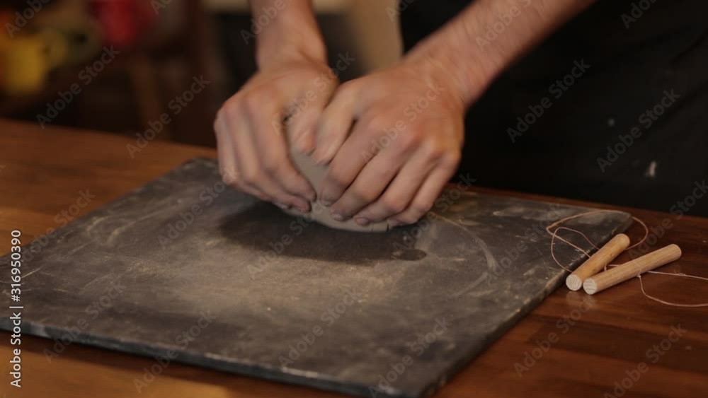 A man kneads clay in a pottery workshop. Male hands closeup knead clay. Clay modeling workshop. A man kneads clay in a pottery workshop. Male hands closeup knead clay. Clay modeling workshop.