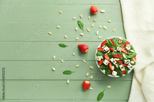 Bowl with tasty salad on wooden background