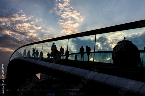 Come back home. It's evening and people cross Calatrava bridge that brings them back to the mainland, Venice, Italy, Europe photo