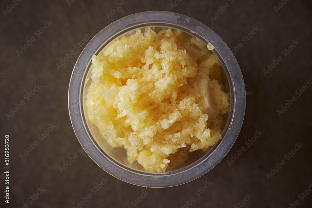 Crushed garlic in plastic bowl 