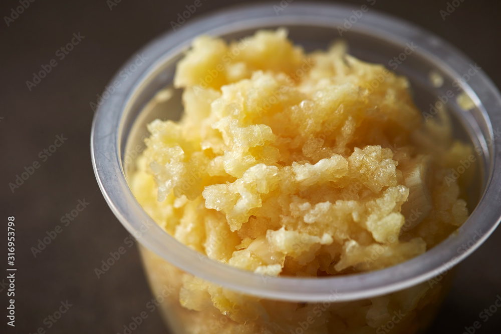Crushed garlic in plastic bowl Crushed garlic in plastic bowl