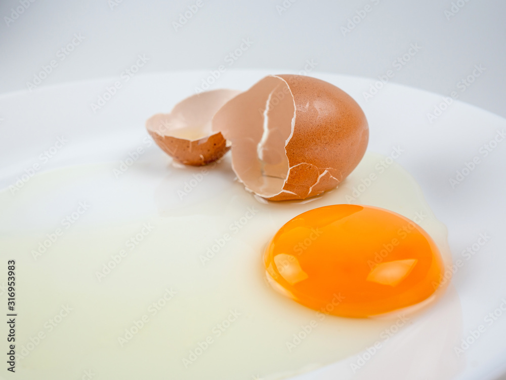 Broken eggs on a plate white background. reddish yellow Broken eggs on a plate white background. reddish yellow