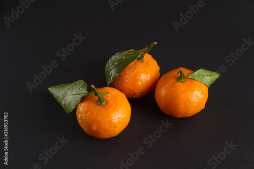 three tangerines on a dark background