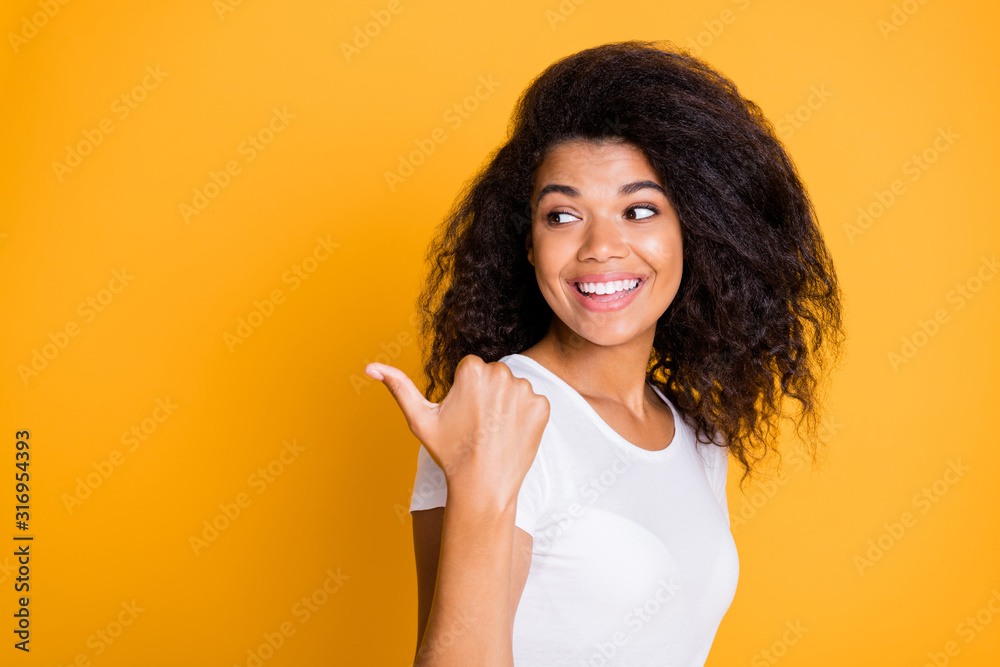 Photo of cheerful positive nice pretty girlfriend pointing at empty space with thumb smiling toothily in white t-shirt isolated vivid color background Photo of cheerful positive nice pretty girlfriend pointing at empty space with thumb smiling toothily in white t-shirt isolated vivid color background