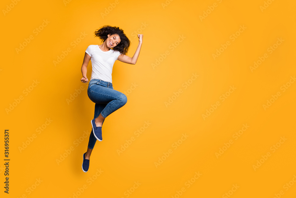 Full length body size photo of cheerful positive curly wavy nice charming girl rejoicing about her team winning the competitions wearing jeans denim white t-shirt isolated vivid color background