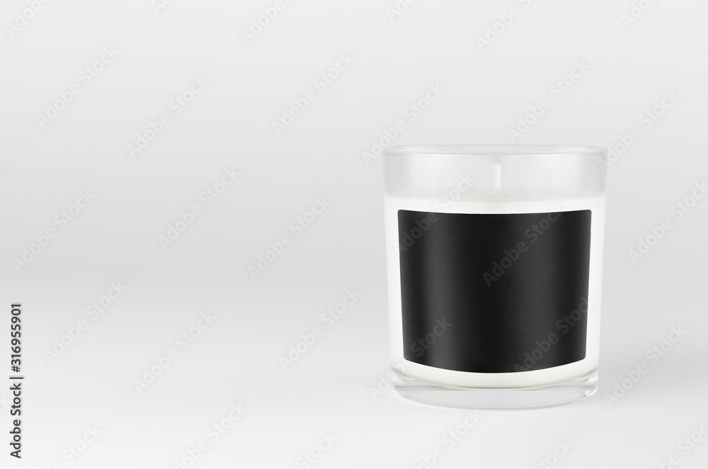 White candle in transparent glass with black blank label on white background, mock up for branding identity, advertising, presentation, design packing. White candle in transparent glass with black blank label on white background, mock up for branding identity, advertising, presentation, design packing.