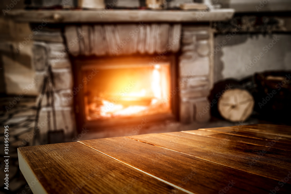 Winter background of wooden table and fireplace 