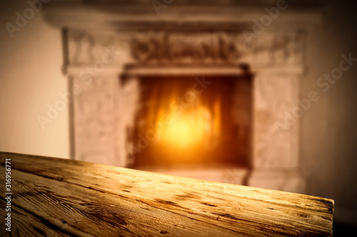 Winter background of wooden table and fireplace 