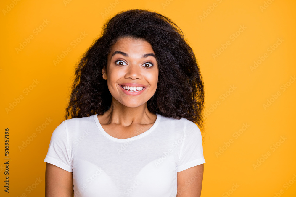 Photo of wavy cheerful cute nice charming attractive toothy beaming girl excited about new information having gifted her good mood isolated over vivid yellow color background