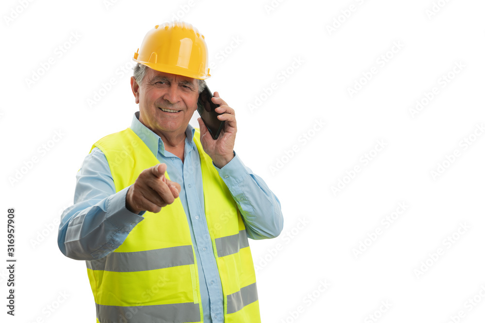 Builder talking on phone and pointing at camera Builder talking on phone and pointing at camera