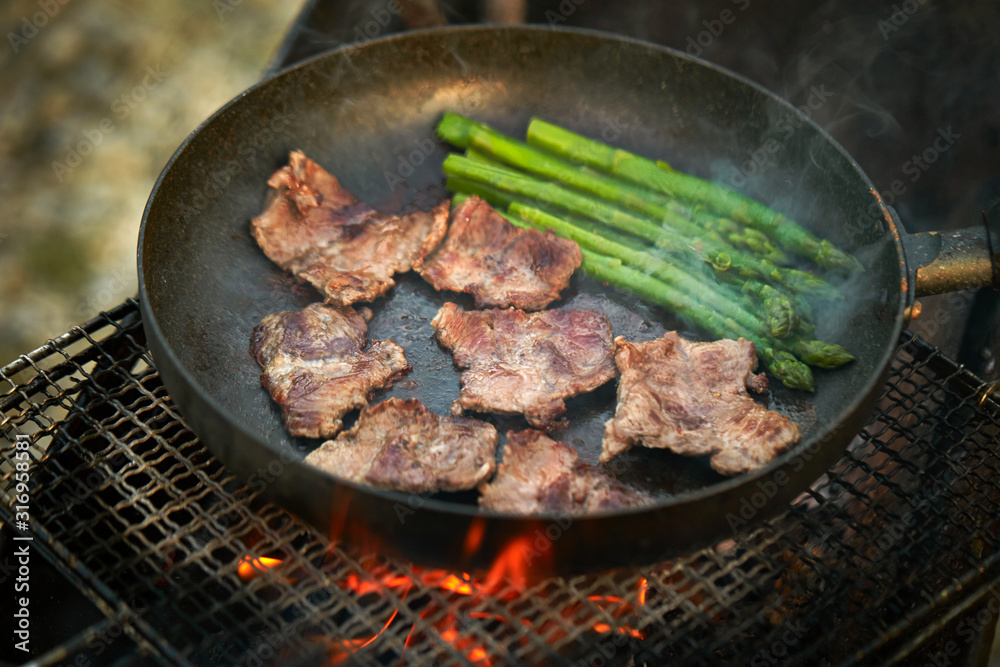 Cooking beef with asparagus on frying pan Cooking beef with asparagus on frying pan