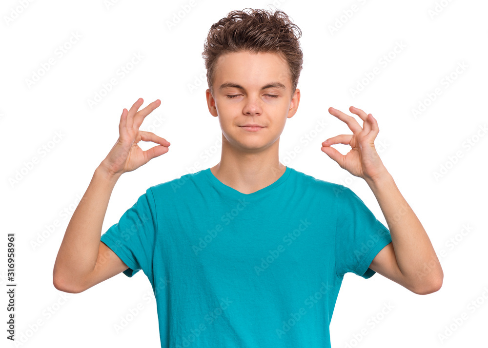 Portrait of successful teen boy holding his fingers in mudra gesture. Zen, meditation, balance and peace concept. Happy cute child with closed eyes, isolated on white background. Portrait of successful teen boy holding his fingers in mudra gesture. Zen, meditation, balance and peace concept. Happy cute child with closed eyes, isolated on white background.