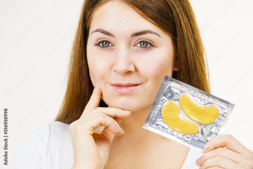 Woman ready to apply gold eye patches Woman ready to apply gold eye patches