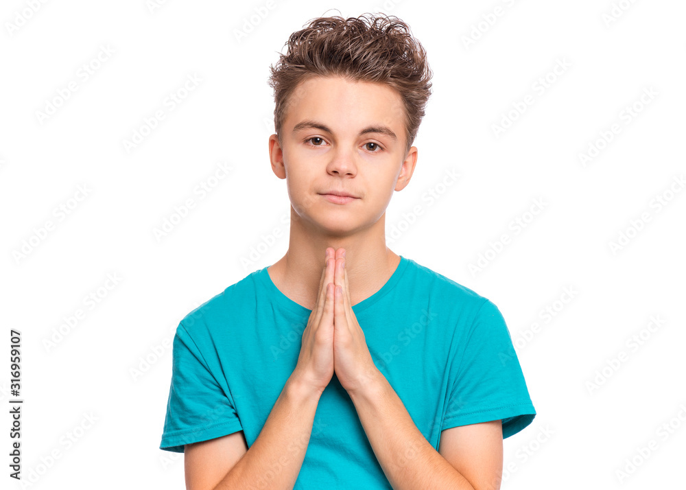 Portrait of teen boy praying, isolated on white background. Cute caucasian teenager with hands folded in prayer hoping for better. Child asking God for good luck, success or forgiveness. Portrait of teen boy praying, isolated on white background. Cute caucasian teenager with hands folded in prayer hoping for better. Child asking God for good luck, success or forgiveness.